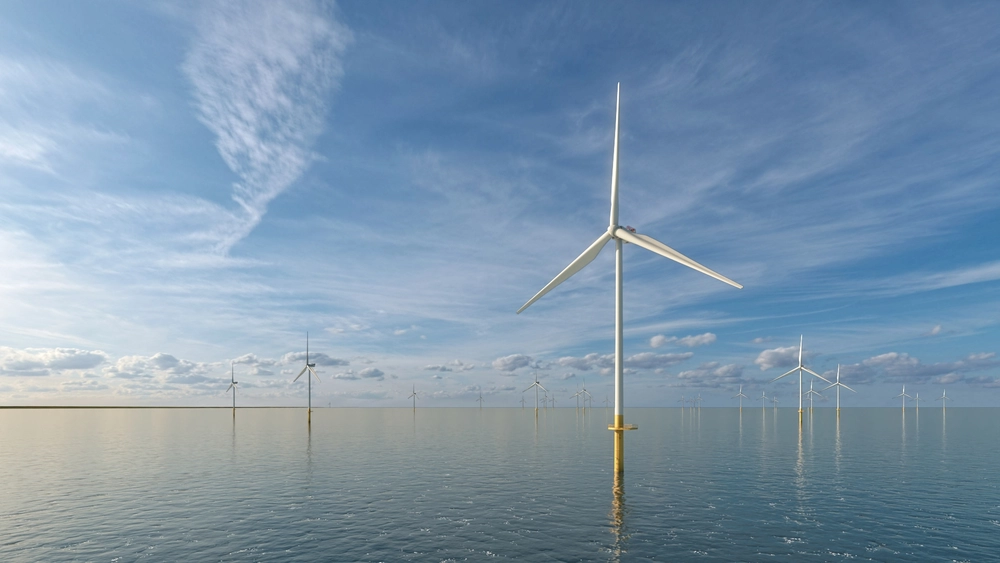 Offshore wind turbines under a partly cloudy sky over calm water