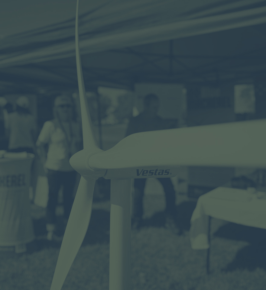Close-up of a Vestas wind turbine model with people in the background under a tent